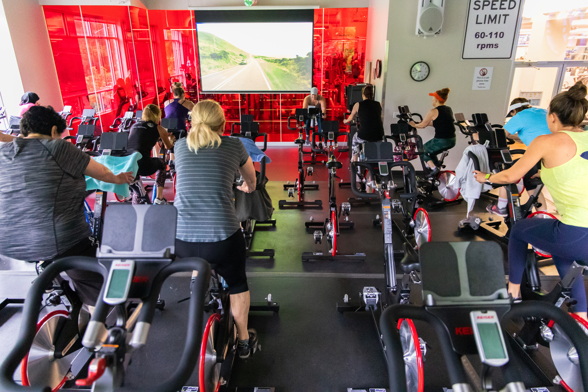 indoor cycle class with cinema seating and screen