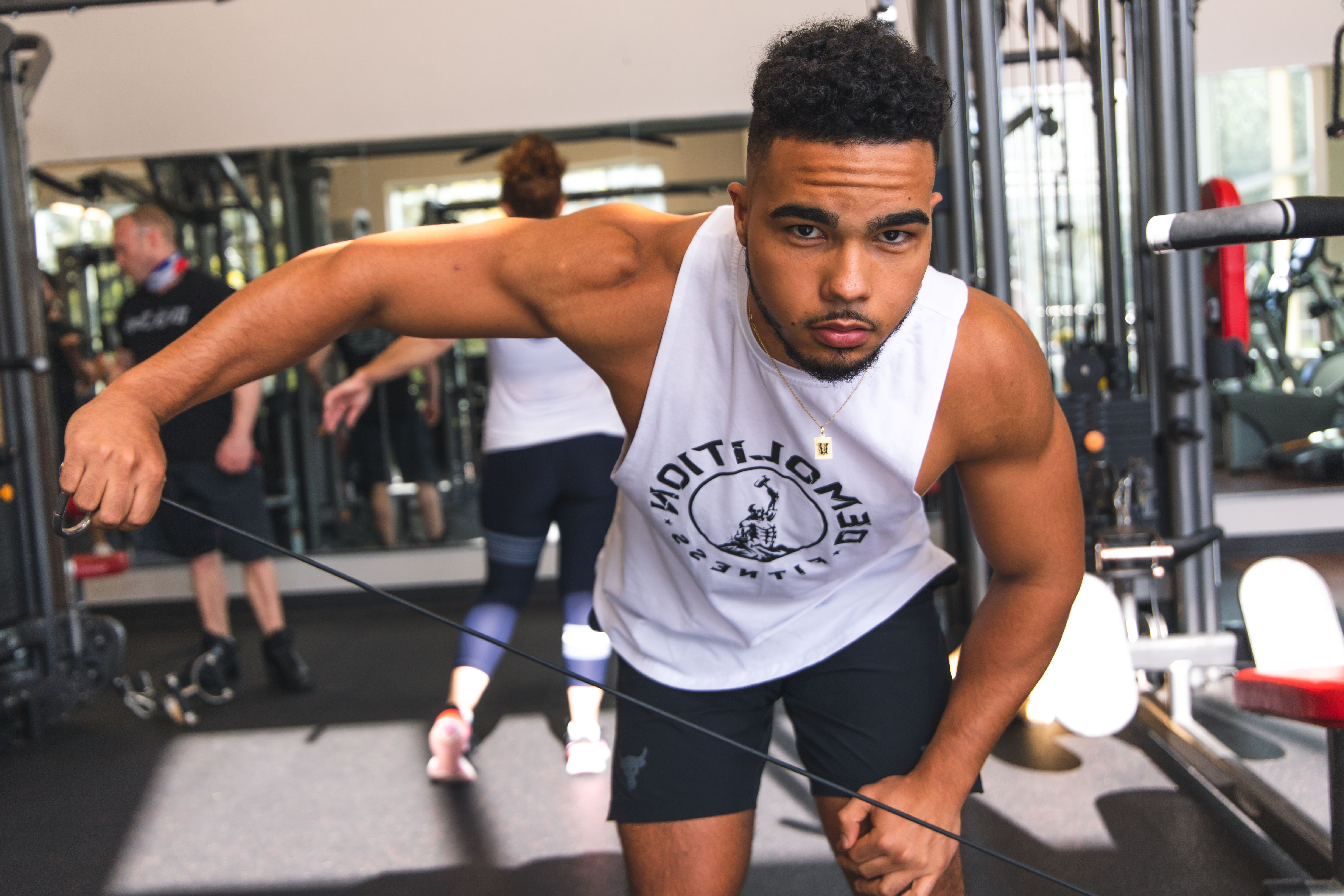 Fit man doing cable arm exercise
