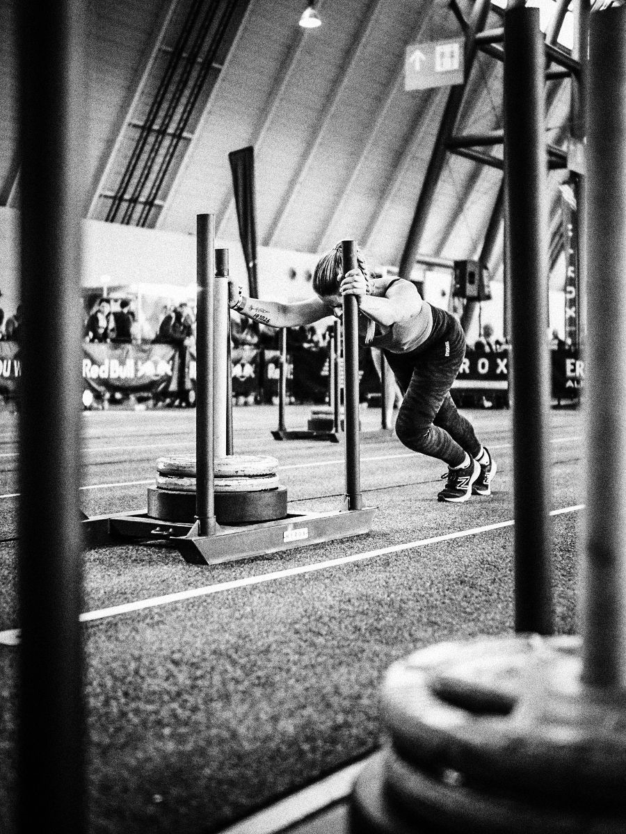 woman pushing sled in hyrox class at gainesville health & fitness, gainesville fl