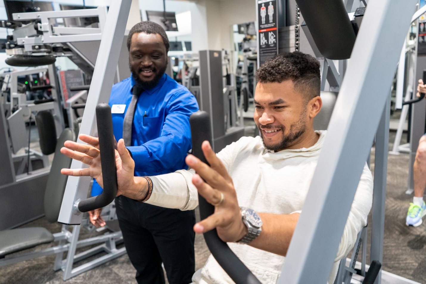 weight lifting circuit at GHF with employee helping member on a machine