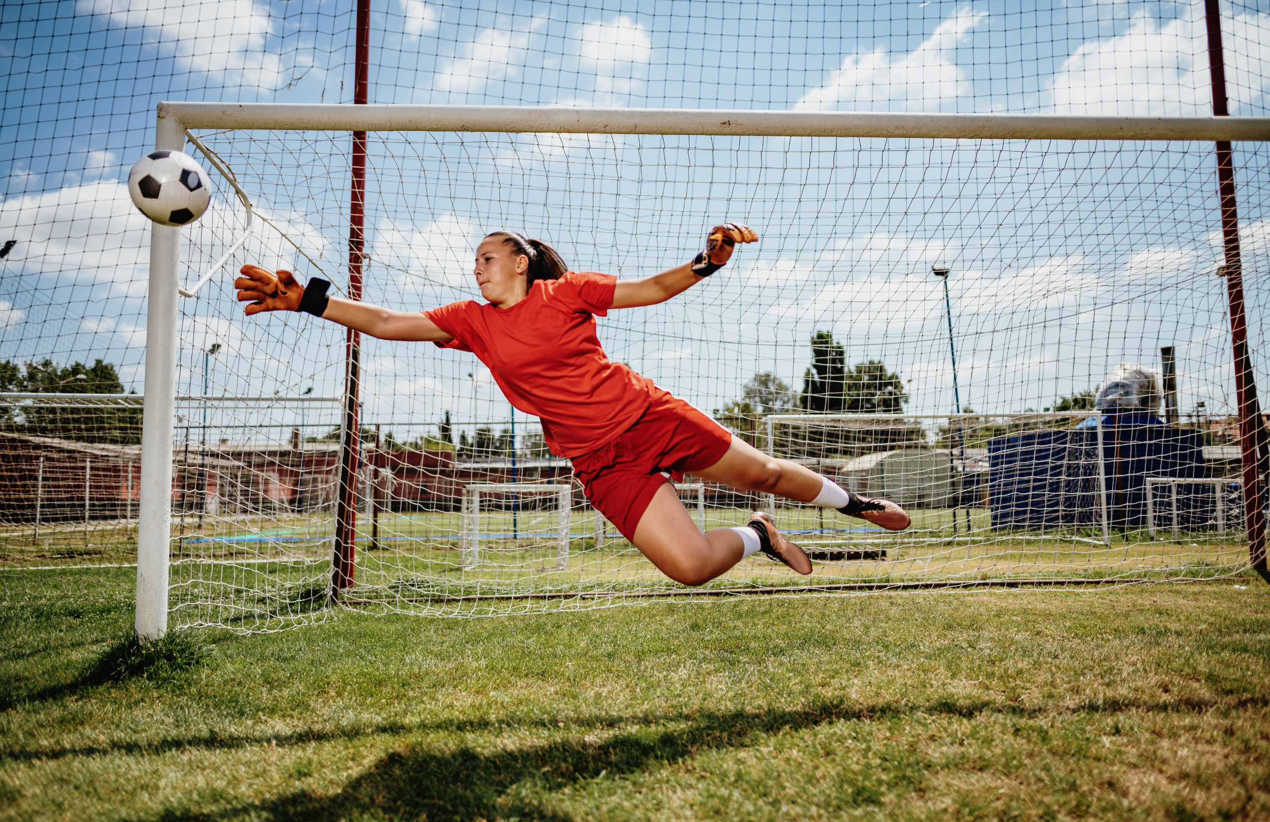 teen goalie blocking a soccer ball goal