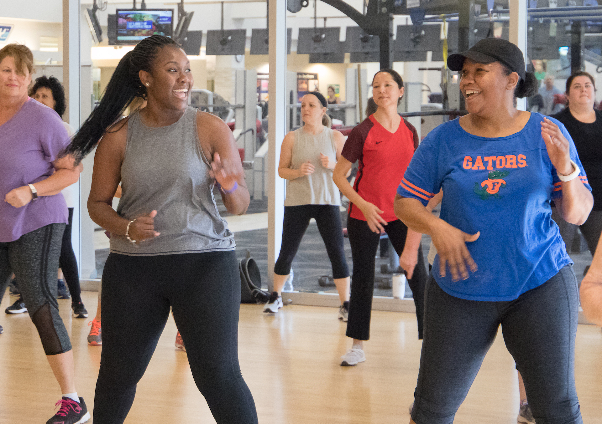 two women smiling in a dance fitness class at the gym